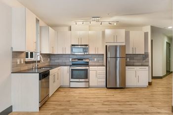 a kitchen with white cabinets and stainless steel appliances